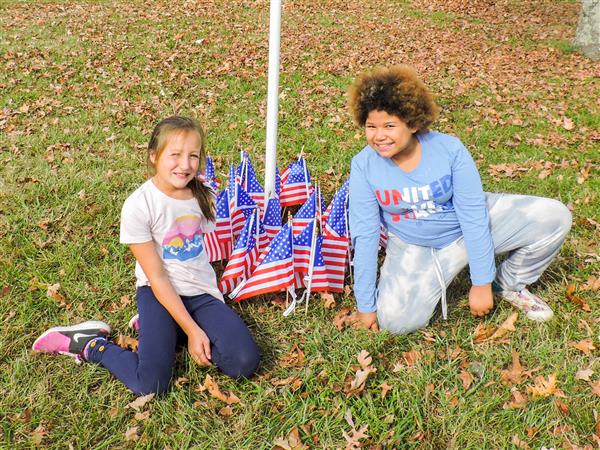 Students holding up homemade signs for a Veterans Day celebration.